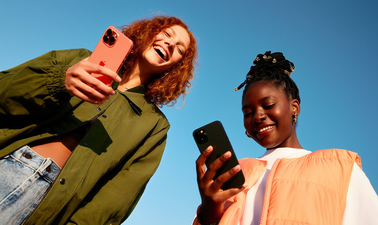 Dos clientas mirando el móvil al aire libre